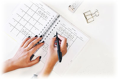 woman's hand writing on calendar